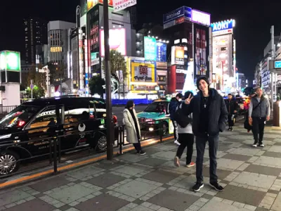 Man standing in front of Ikebukuro station at night in Tokyo, Japan