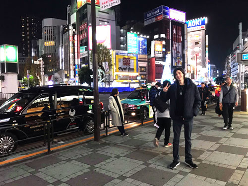 Man standing in front of Ikebukuro station at night in Tokyo, Japan
