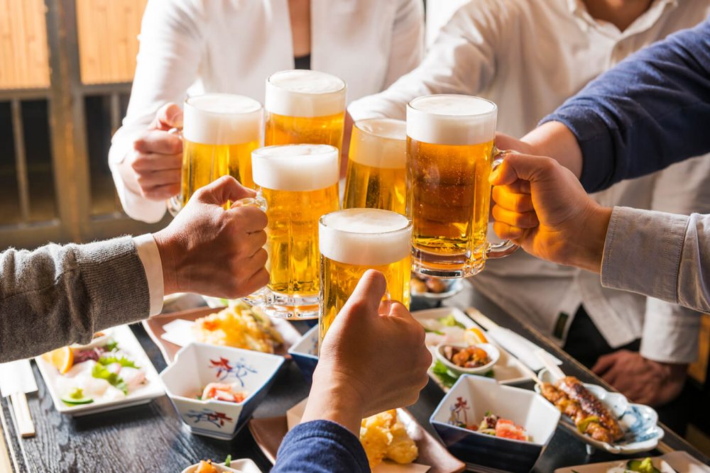 Japanese men toasting with beer in an izakaya in Japan