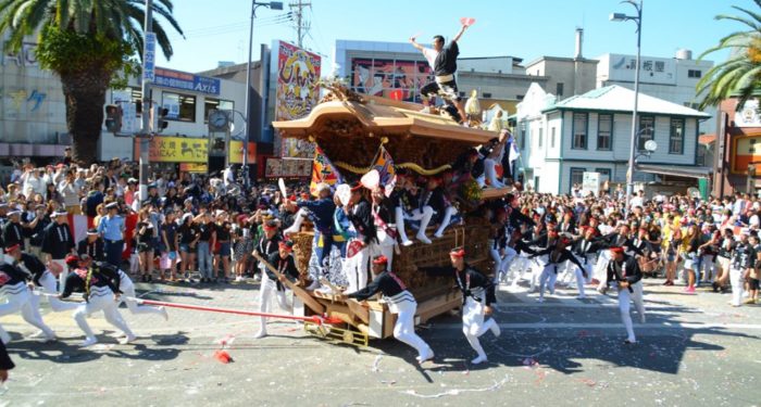 Men pulling a heavy float during the Danjiri Matsuri festival in Osaka, Japan