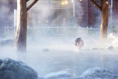 Woman in outdoor onsen hot spring in Kusatsu, Japan