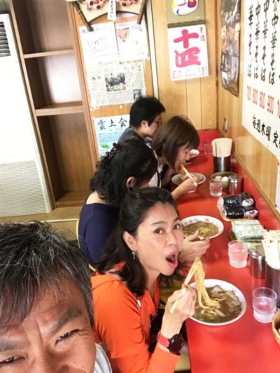 Tourists eating ramen noodles in a noodle bar in Japan