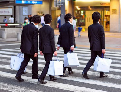 Business men (salary men) wearing identical suits walking on the street in Japan