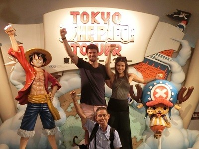 Guide and tourists posing with One Piece anime characters in Tokyo, Japan