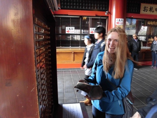 Tourist getting an omikuji fortune telling paper in the Sensoji temple in Tokyo, Japan