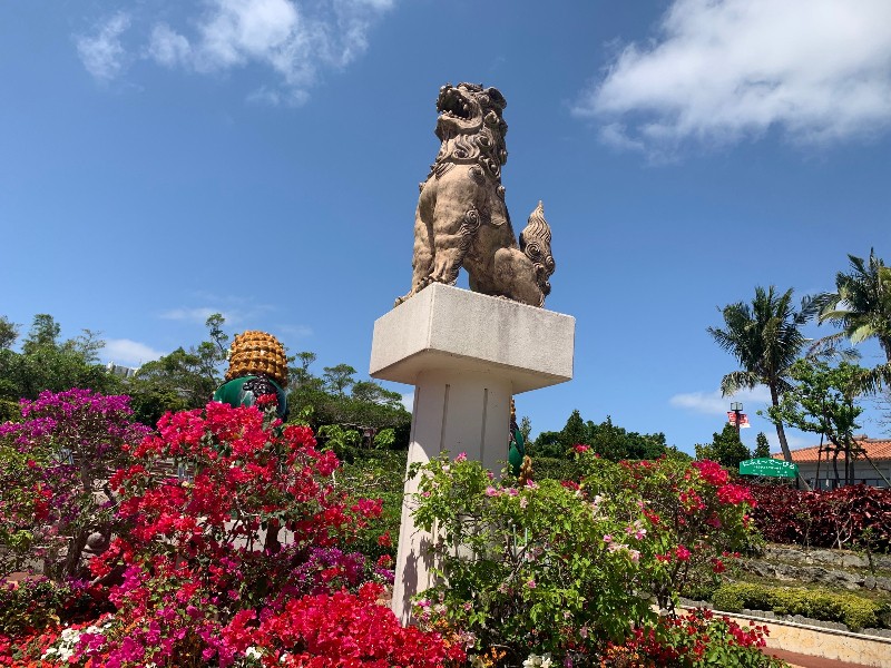 Flowers and shisa lion at the entrance of Okinawa World